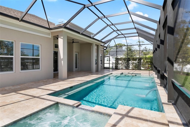 view of pool featuring ceiling fan, a lanai, pool water feature, a patio area, and an in ground hot tub