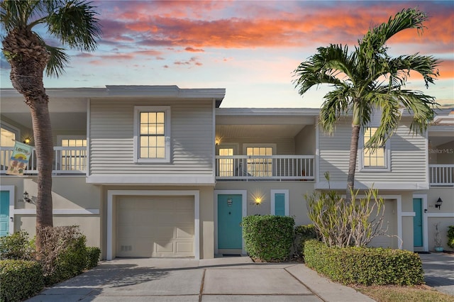 townhome / multi-family property featuring a balcony and a garage