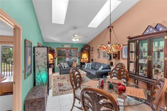 dining room featuring ceiling fan, lofted ceiling with skylight, and light tile patterned floors