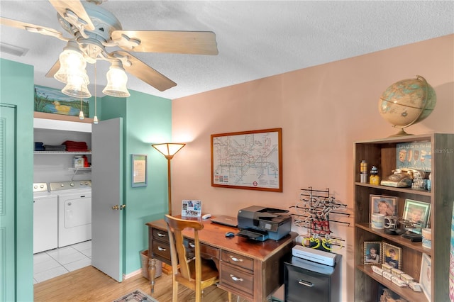 office featuring ceiling fan, washing machine and dryer, light wood-type flooring, and a textured ceiling