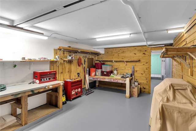 basement with a workshop area and wood walls