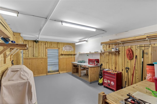 basement featuring a workshop area and wood walls