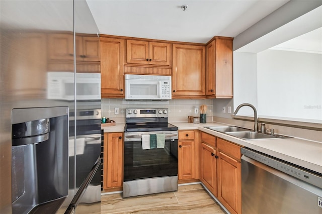 kitchen featuring tasteful backsplash, sink, stainless steel appliances, and light hardwood / wood-style flooring