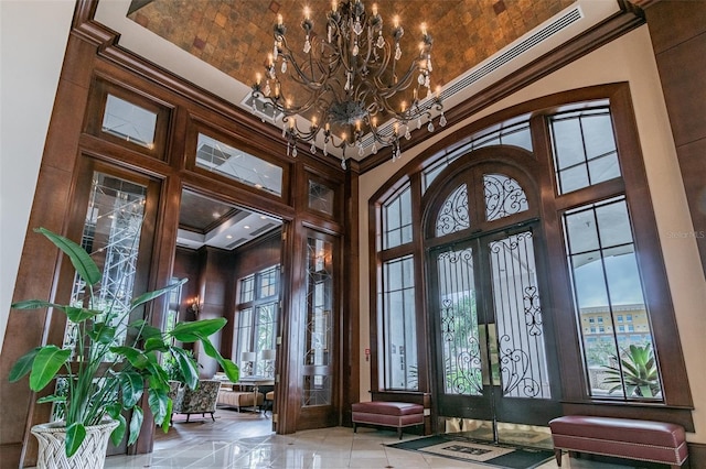 interior space featuring a high ceiling, a wealth of natural light, french doors, and a notable chandelier