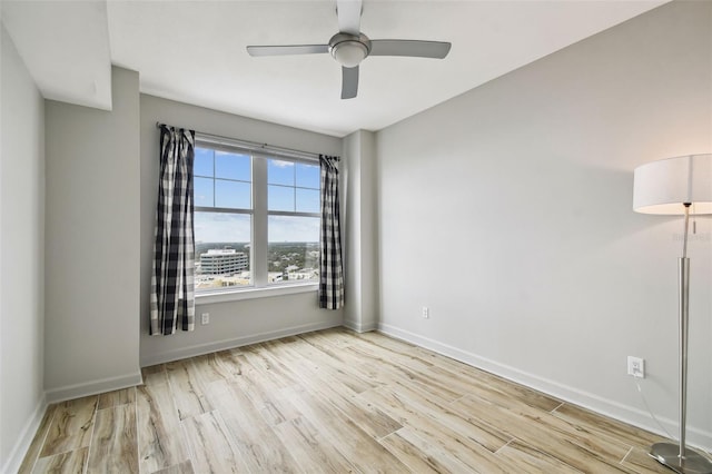 empty room with ceiling fan and light wood-type flooring