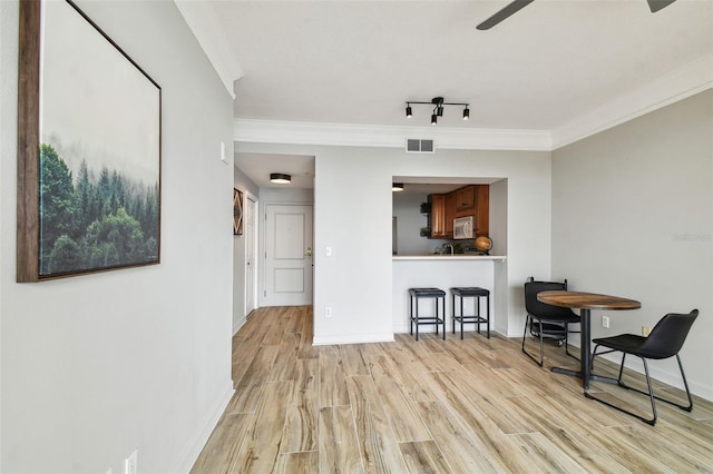 interior space with light hardwood / wood-style flooring and ornamental molding