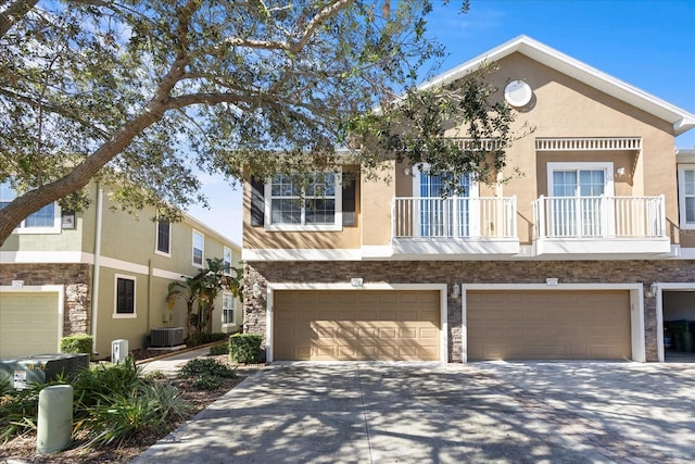 multi unit property with a balcony, a garage, and cooling unit