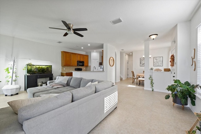 living room with ceiling fan and sink