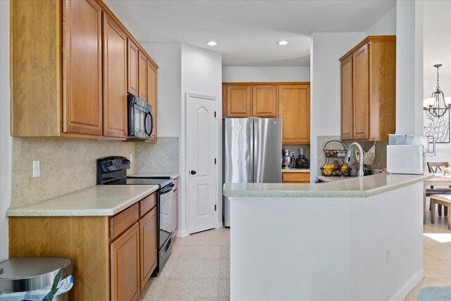 kitchen with backsplash, sink, black appliances, decorative light fixtures, and a notable chandelier