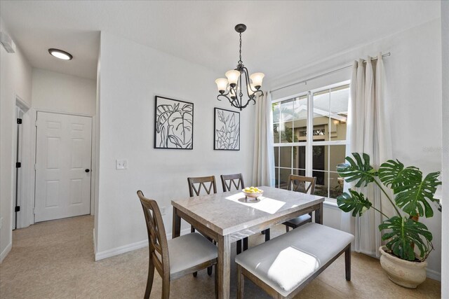 dining room with light colored carpet and a notable chandelier