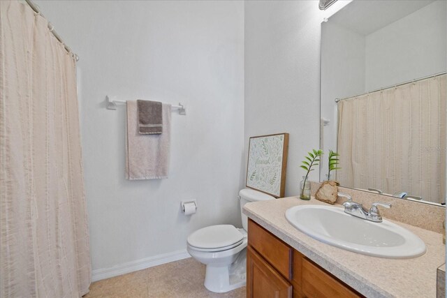 bathroom featuring tile patterned flooring, vanity, and toilet