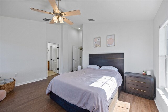 bedroom with ceiling fan, dark hardwood / wood-style floors, lofted ceiling, and ensuite bath