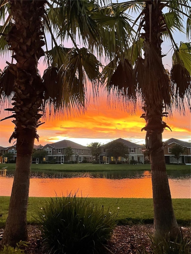 view of home's community with a water view and a yard