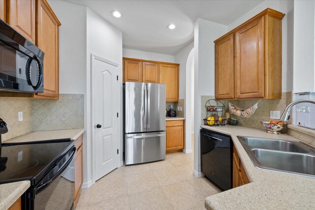 kitchen featuring backsplash, sink, and black appliances