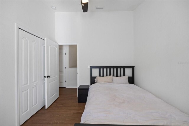 bedroom featuring dark hardwood / wood-style floors, ceiling fan, and a closet