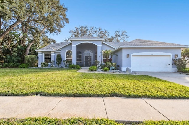 view of front of property with a garage and a front lawn