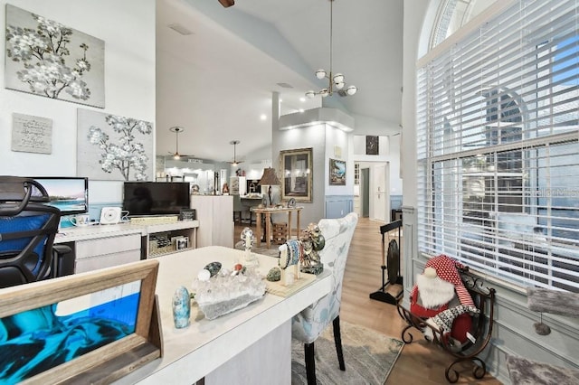 dining room featuring an inviting chandelier, hardwood / wood-style flooring, high vaulted ceiling, and a healthy amount of sunlight