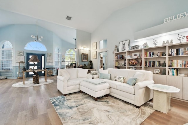 living room featuring wood-type flooring and high vaulted ceiling