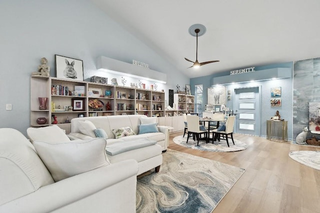 living room featuring ceiling fan, wood-type flooring, and vaulted ceiling