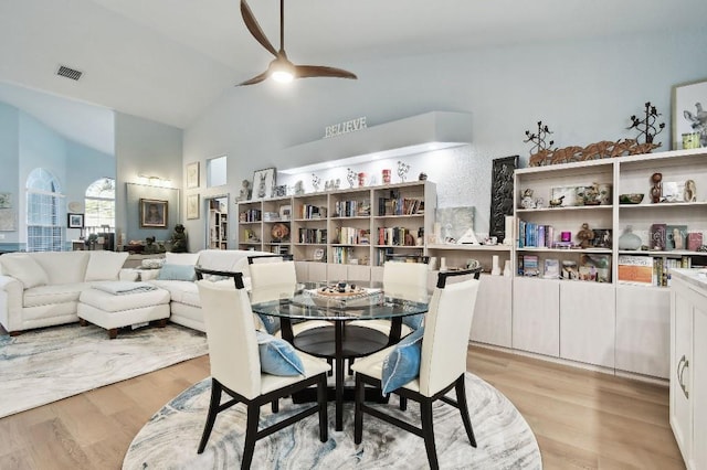 dining space with light wood-type flooring, vaulted ceiling, and ceiling fan