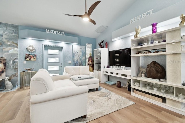 living room with hardwood / wood-style flooring, vaulted ceiling, and ceiling fan