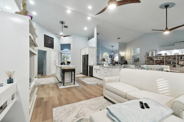 living room featuring light hardwood / wood-style floors, sink, and high vaulted ceiling