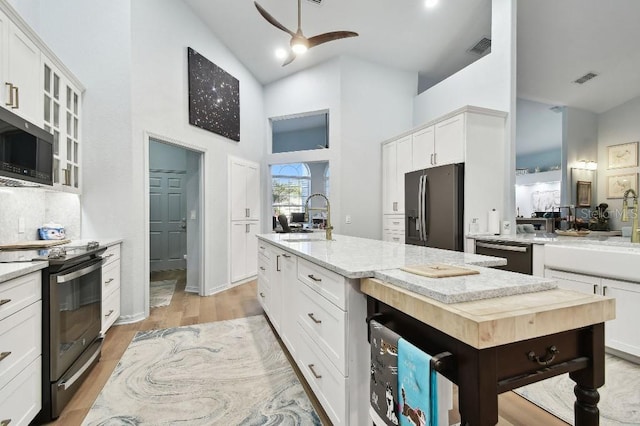 kitchen featuring white cabinetry, a center island, stainless steel appliances, and sink