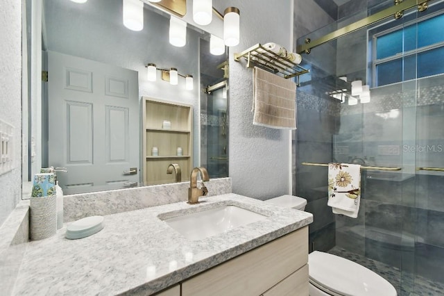 bathroom featuring vanity, an enclosed shower, and toilet