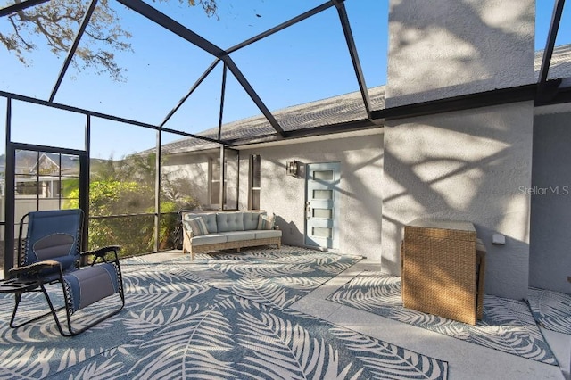 view of patio featuring glass enclosure