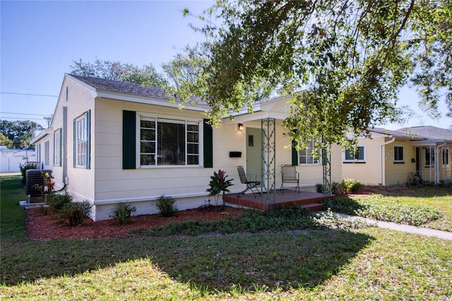 view of front facade featuring a front yard, a porch, and central AC unit