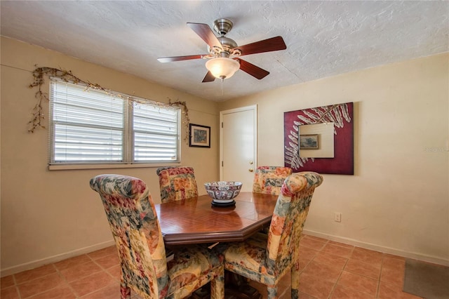 tiled dining space featuring a textured ceiling and ceiling fan