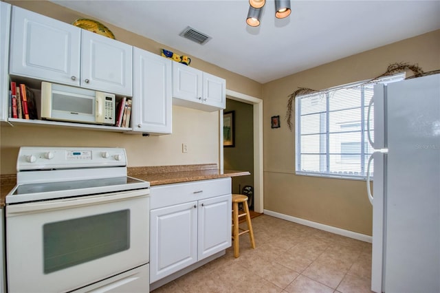 kitchen featuring white cabinets, white appliances, and light tile patterned floors