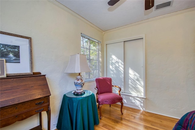 sitting room featuring crown molding, ceiling fan, and light wood-type flooring