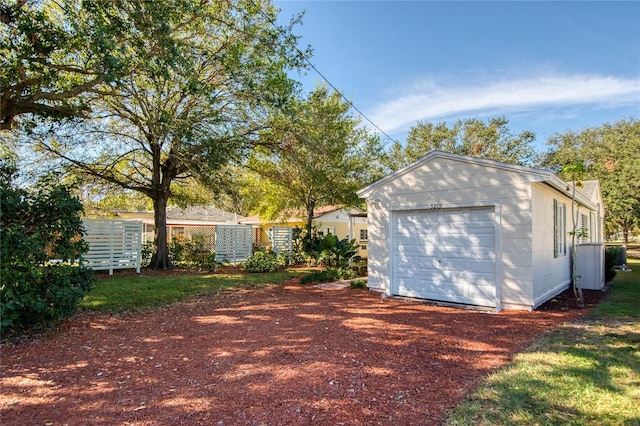 view of side of home with a garage and an outbuilding