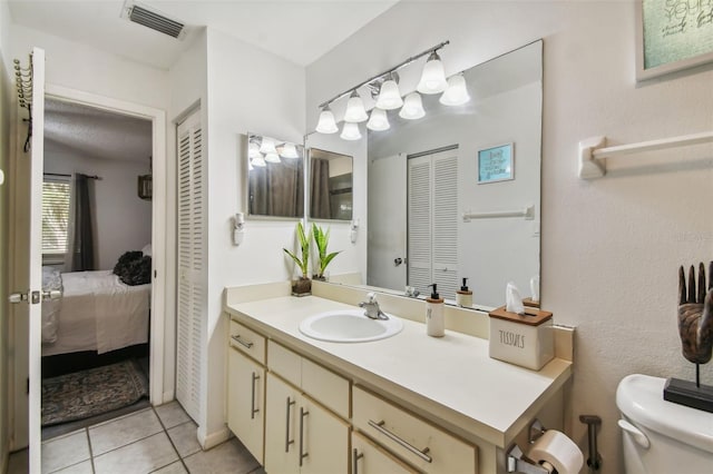 bathroom featuring tile patterned floors, vanity, and toilet