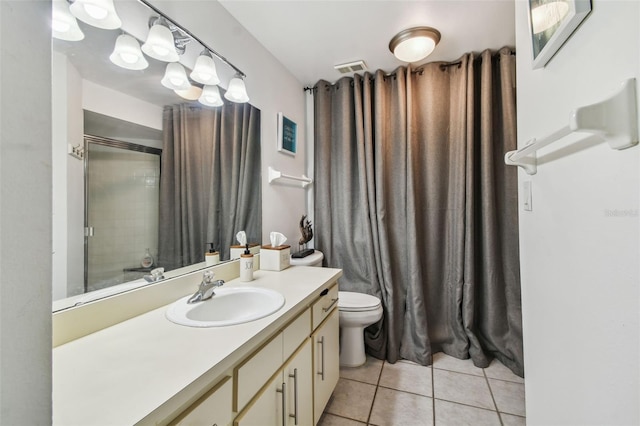 bathroom featuring toilet, a shower, vanity, and tile patterned floors