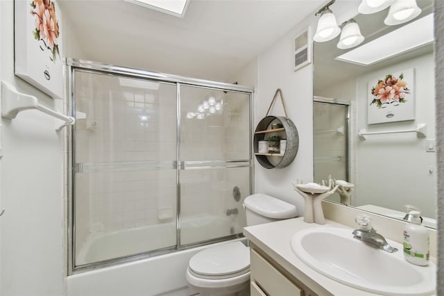 full bathroom with vanity, toilet, and shower / bath combination with glass door