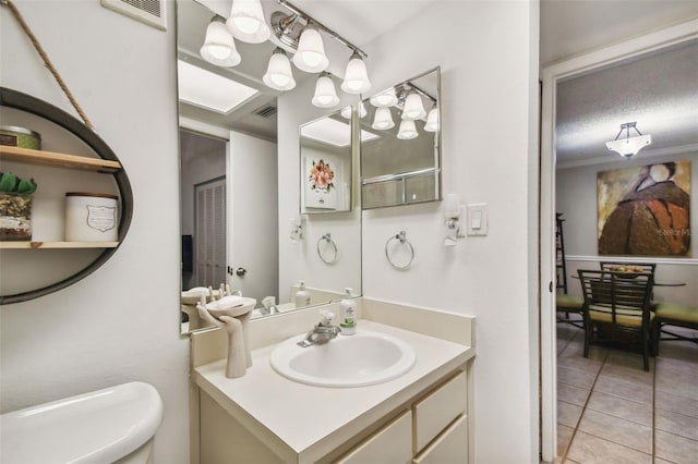 bathroom featuring tile patterned floors, vanity, and toilet