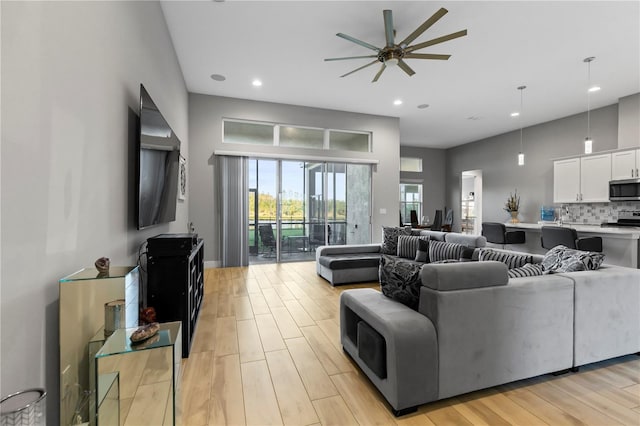 living room with light wood-type flooring and ceiling fan