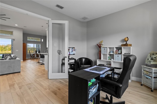 home office with ceiling fan, french doors, and light hardwood / wood-style flooring