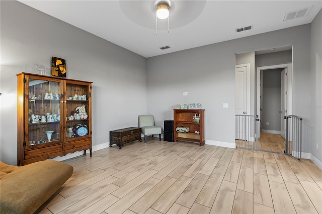 living area with light hardwood / wood-style flooring and ceiling fan