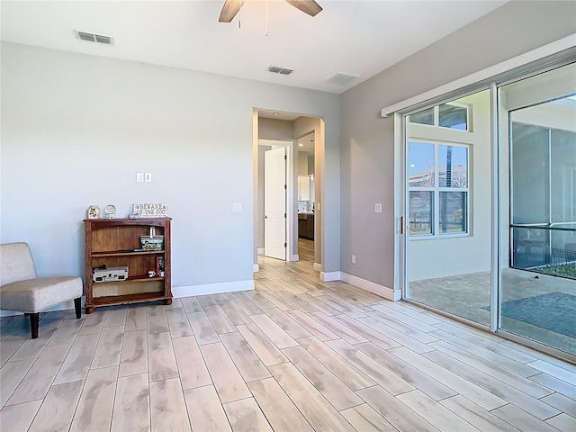 sitting room with light wood-style floors, visible vents, and ceiling fan