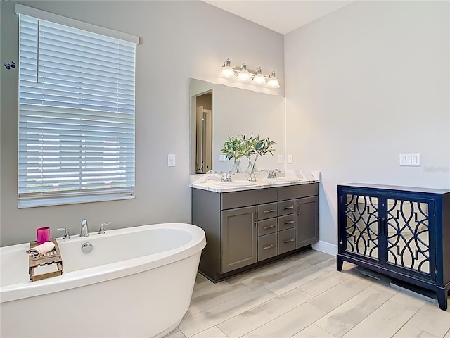 bathroom with a soaking tub, wood finished floors, double vanity, and a sink