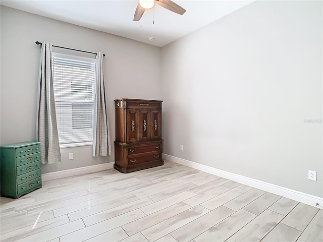 unfurnished bedroom featuring a ceiling fan, light wood-style floors, and baseboards