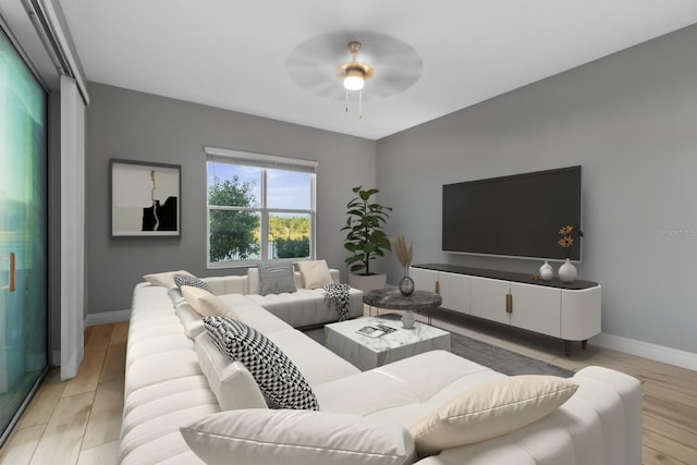 living area featuring light wood-type flooring, baseboards, and a ceiling fan