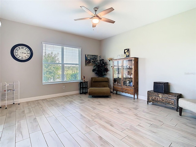 sitting room with baseboards and ceiling fan