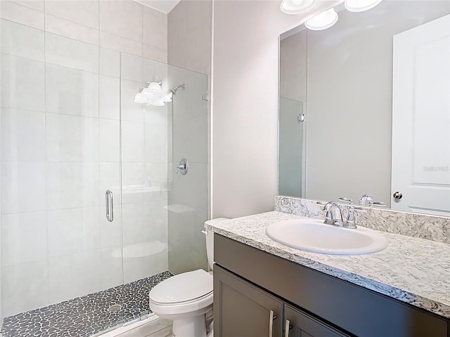 full bathroom with a shower stall, toilet, and vanity