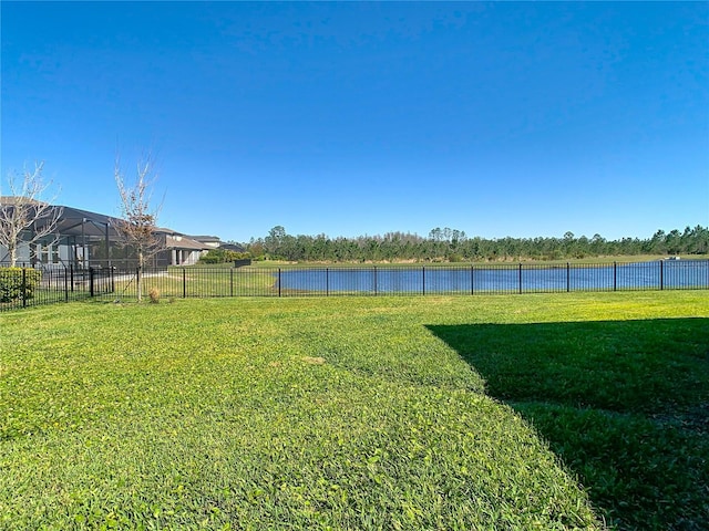 view of yard with a water view and fence