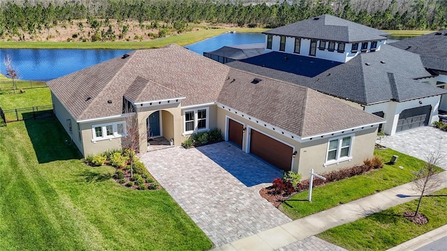 3901 Tour Trce, Land O Lakes, FL 34638 - view of front of home with stucco siding, driveway, a garage, a water view, and roof with shingles