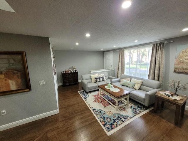 living room featuring dark wood-type flooring and a textured ceiling